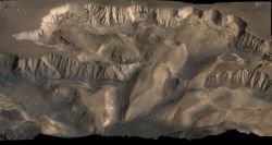 This oblique image looking north over central Valles Marineris shows Ophir Chasma (top) and Candor Chasma (lower). The connected rift valleys and basins within Valles Marineris likely formed from a combination of tectonic faulting, groundwater escape, and erosional collapse. (NASA/JPL-Caltech/US Geological Survey)