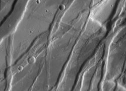 A graben is usually a small-scale tectonic feature, where the ground between two faults drops down. (If the ground is raised, scientists call it a horst.) Tempe Fossae is a large area on Mars much broken up by grabens. (NASA/JPL-Caltech/Arizona State University) 